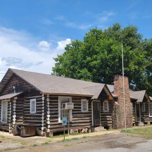 Single story log cabin with rock fireplace/chimney