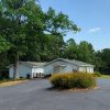 White wooden church building with large parking lot