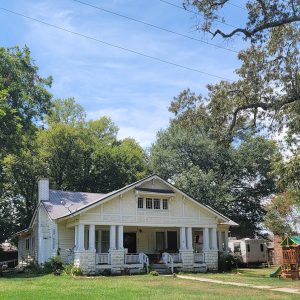 Multistory white wooden house with large front porch