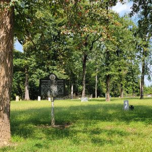 Grassy area with tombstones and an information sign saying "Temperance Chapel Cemetery and site of a Methodist Church South"