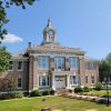 Multistory tan brick building with clock in tower and words across front of building saying "Cleveland County Court House"