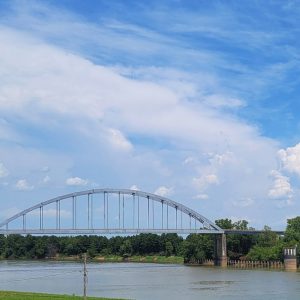 arched bridge over river lined with trees