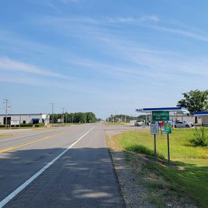 Road entering small town with businesses on the corners