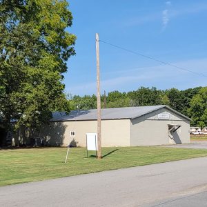 Single story white concrete mostly windowless block building with sign saying "Garner Recreational Center"