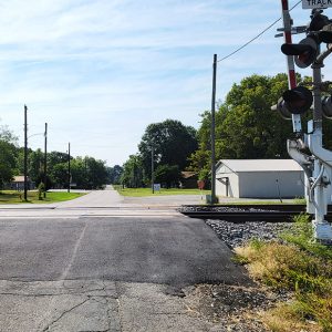 Road crossing railroad tracks with buildings