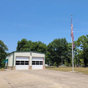 Single-story white metal building with two bay doors