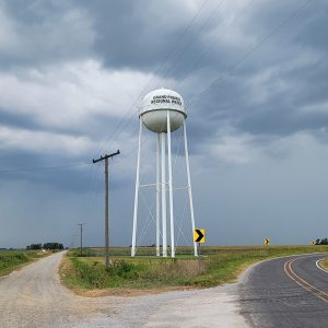 white water tower at the fork in the road printed with "Grand Prairie Regional Water"