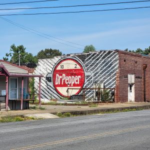 Large mural with circle saying "Drink Doctor Pepper" on side of brick building