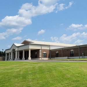 Multistory red brick building with covered entrance with multiple columns