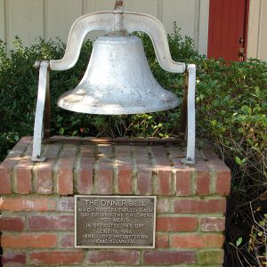 Large metal bell with plaque saying "The Dinner Bell"