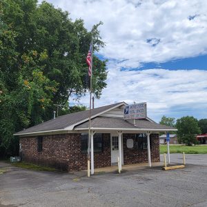 Single story red brick building with parking lot