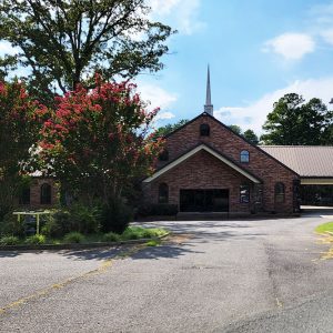 Multistory red brick church building with steeple