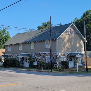 Multistory stone and stucco library building with covered entrances