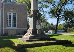 Statue and obelisk in front of building