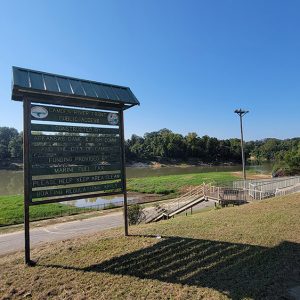 Park area with metal stairs leading down to a river