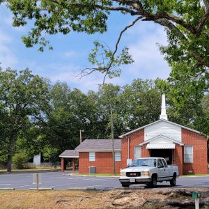 Red brick church building with steeple