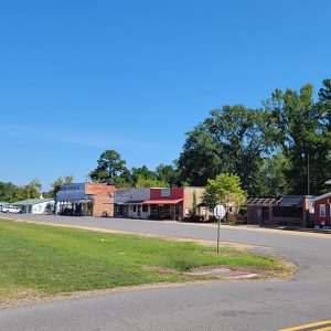 Small town street scene with intersection and businesses in a row