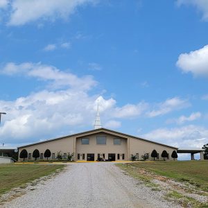 Multistory tan brick church building with covered side entrances