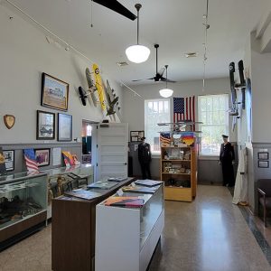 Room full of museum displays of uniforms