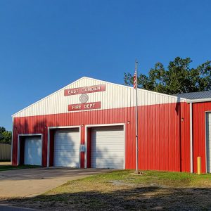 Red and white metal building with four bay doors