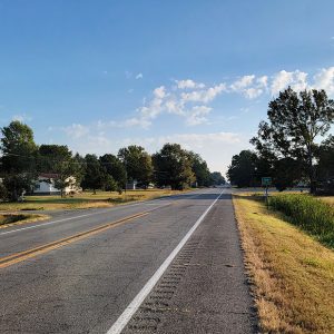 Entering small town on country highway with trees and buildings on both sides