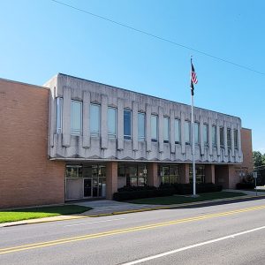 Multistory orange brick and concrete structure with flag pole