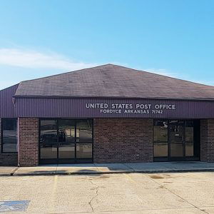 Single story red brick building with parking lot