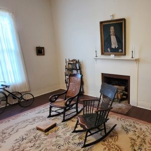 Wallpapered room with antique furniture and fireplace