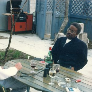 African American man with glasses sitting at picnic table with white man