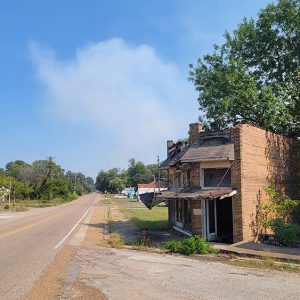 Small town street with dilapidated buildings and trees and power lines