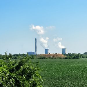 Power station towers emitting steam in background