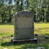 Concrete monument with words inscribed and trees in background