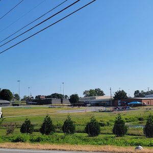 Multiple differently constructed school buildings in the background; playground in the foreground