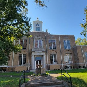 Multistory tan brick courthouse building with clock tower