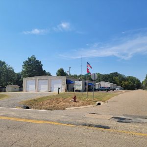 Single story beige metal building with three bay doors