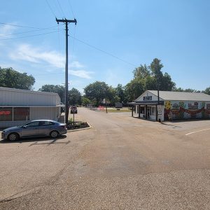 curving road with parked car and small business buildings