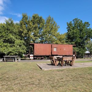 Red rail boxcar "Southern Pacific" with trees in background