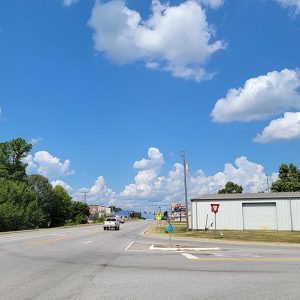 Road entering small community of scattered single story buildings