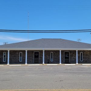 Single story brown brick building with parking lot