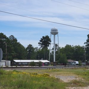 Small village street scene with buildings as seen from across railroad tracks