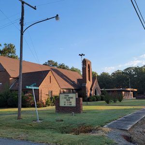 large red brick church building with tower in front