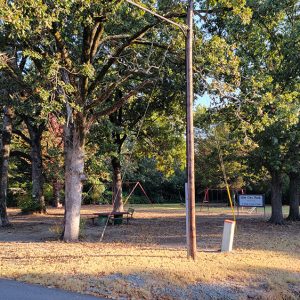 Small park with picnic tables and children's playground equipment