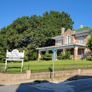 Multistory tan brick house with front porch