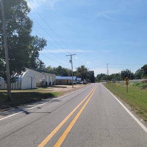 Small town road with commercial buildings and railroad tracks