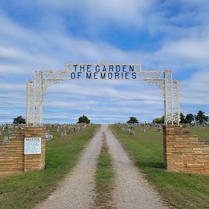 Cemetery with arched entrance and gravestones and long gravel path