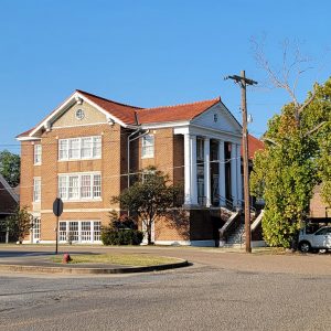 Multistory tan brick building with red roof