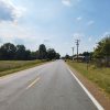 Country road with a few buildings and brush