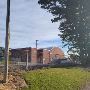 red brick school buildings behind chain link fence