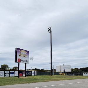 Stadium behind fence with many signs on it.