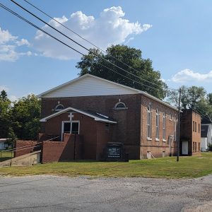 brown brick church building with stairs and ramp leading up to entrance